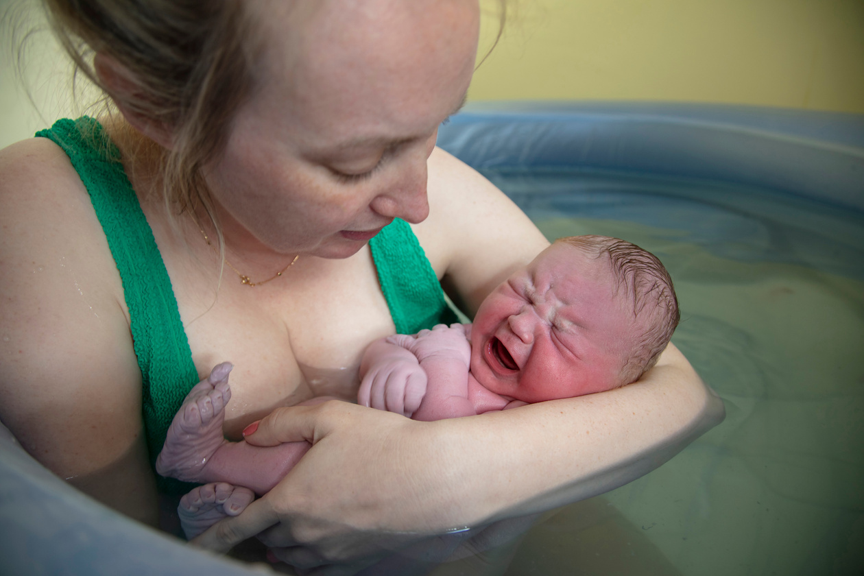 New Mother Embracing Her Newborn Baby after Home Birth